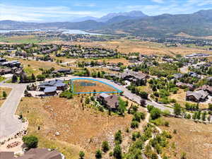 Aerial view of residential area with a water and mountain view and property parcel outlined