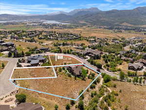 Aerial perspective of suburban area featuring a mountainous background and property parcel outlined