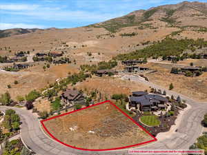 Aerial view of property and surrounding area featuring property parcel outlined and a mountain backdrop