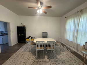 Dining room with dark wood-style floors and a ceiling fan