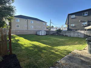 Fenced backyard with a storage shed