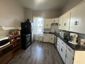 Kitchen featuring stainless steel appliances, dark wood finished floors, and white cabinetry