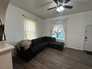 Living area with dark wood-style flooring and a ceiling fan