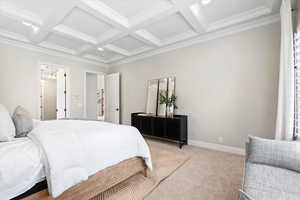 Carpeted bedroom with beamed ceiling, ornamental molding, and coffered ceiling
