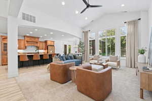 Living room featuring recessed lighting, a ceiling fan, high vaulted ceiling, light wood-type flooring, and arched walkways