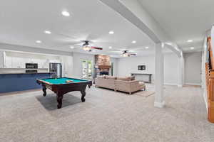 Rec room featuring arched walkways, a fireplace, recessed lighting, light colored carpet, and billiards