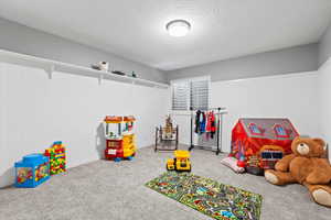 Game room featuring a textured ceiling and carpet