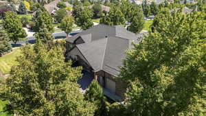 Aerial view of property and surrounding area with a tree filled landscape