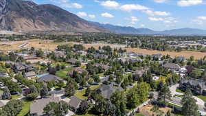 Aerial view of property and surrounding area featuring a mountainous background and nearby suburban area