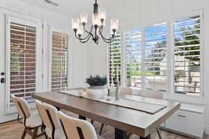 Dining area featuring light wood-type flooring and a chandelier