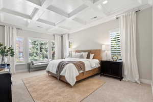 Bedroom with light carpet, beam ceiling, and coffered ceiling