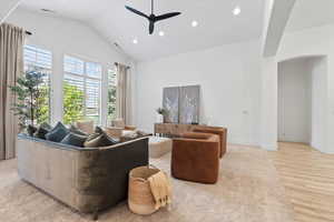 Living area featuring arched walkways, lofted ceiling, a ceiling fan, recessed lighting, and light wood-style floors