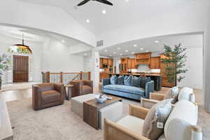 Living room featuring recessed lighting, high vaulted ceiling, light wood-type flooring, arched walkways, and a ceiling fan
