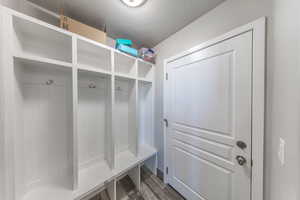 Mudroom with a textured ceiling and dark wood-style flooring