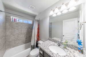 Bathroom featuring shower / tub combo with curtain and vanity
