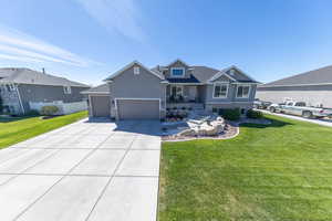 Craftsman inspired home featuring stone siding, covered porch, a front yard, concrete driveway, and an attached garage