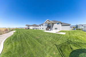 Rear view of property featuring patio area with a fire pit and landscaped yard
