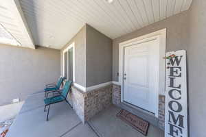 Property entrance featuring stone siding and stucco siding