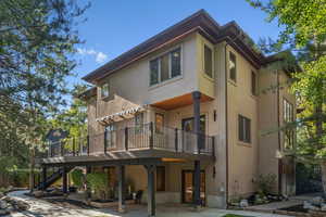 Rear view of property featuring stucco siding and stairs
