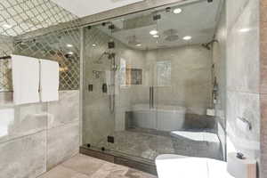 Full bathroom featuring a shower stall, a freestanding tub, and recessed lighting