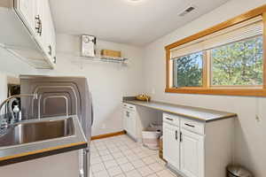 Laundry room with light tile patterned flooring and washer / dryer