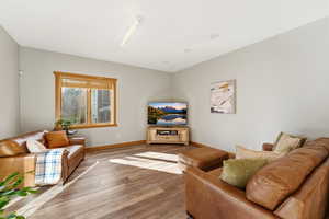 Living room with wood-type flooring and baseboards