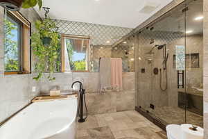 Full bathroom featuring a shower stall, a freestanding bath, tile walls, and recessed lighting