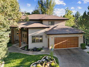 Prairie-style home with stucco siding, a garage, concrete driveway, and roof with shingles