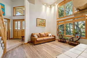 Living room featuring a high ceiling, stairs, and wood finished floors