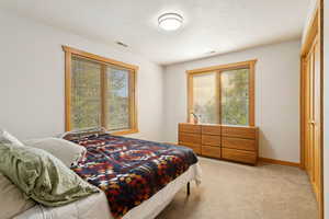 Bedroom featuring light carpet and baseboards