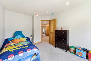 Bedroom featuring light colored carpet and baseboards