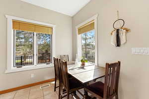 Dining area with light tile patterned floors and baseboards