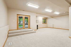Below grade area with french doors and carpet floors