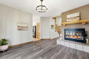 Unfurnished living room featuring light wood finished floors, a fireplace, and hanging lights