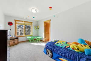 Bedroom with light colored carpet and baseboards