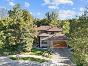 View of front of home featuring concrete driveway, stucco siding, a front lawn, and an attached garage