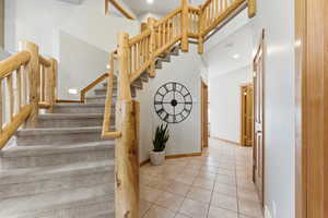 Stairway with recessed lighting, tile patterned flooring, and a high ceiling