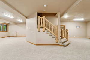 Basement featuring carpet floors and stairs