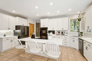 Kitchen with decorative backsplash, light tile patterned floors, white cabinetry, and recessed lighting