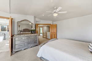 Bedroom featuring vaulted ceiling, light colored carpet, and ceiling fan
