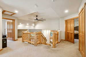 Hall with an upstairs landing, carpet floors, and recessed lighting