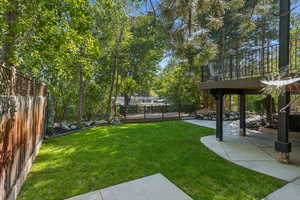 Fenced backyard featuring a deck, a patio area, and stairway