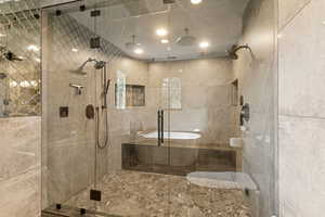 Bathroom featuring a shower stall and tile walls