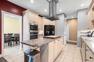 Kitchen featuring island exhaust hood, stainless steel appliances, a center island, light tile patterned floors, and recessed lighting