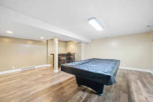 Playroom featuring light wood-style floors, billiards, recessed lighting, and a bar