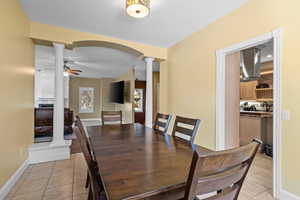 Dining room featuring decorative columns and light tile patterned floors