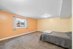 Bedroom featuring carpet and baseboards