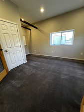 Room with gray carpet and recessed lighting and a bathroom