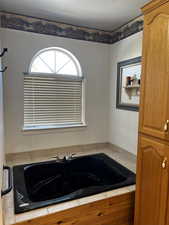 Master Bathroom featuring a jetted tub and a textured ceiling