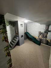 Basement Bedroom with carpet, a textured ceiling, and stairs